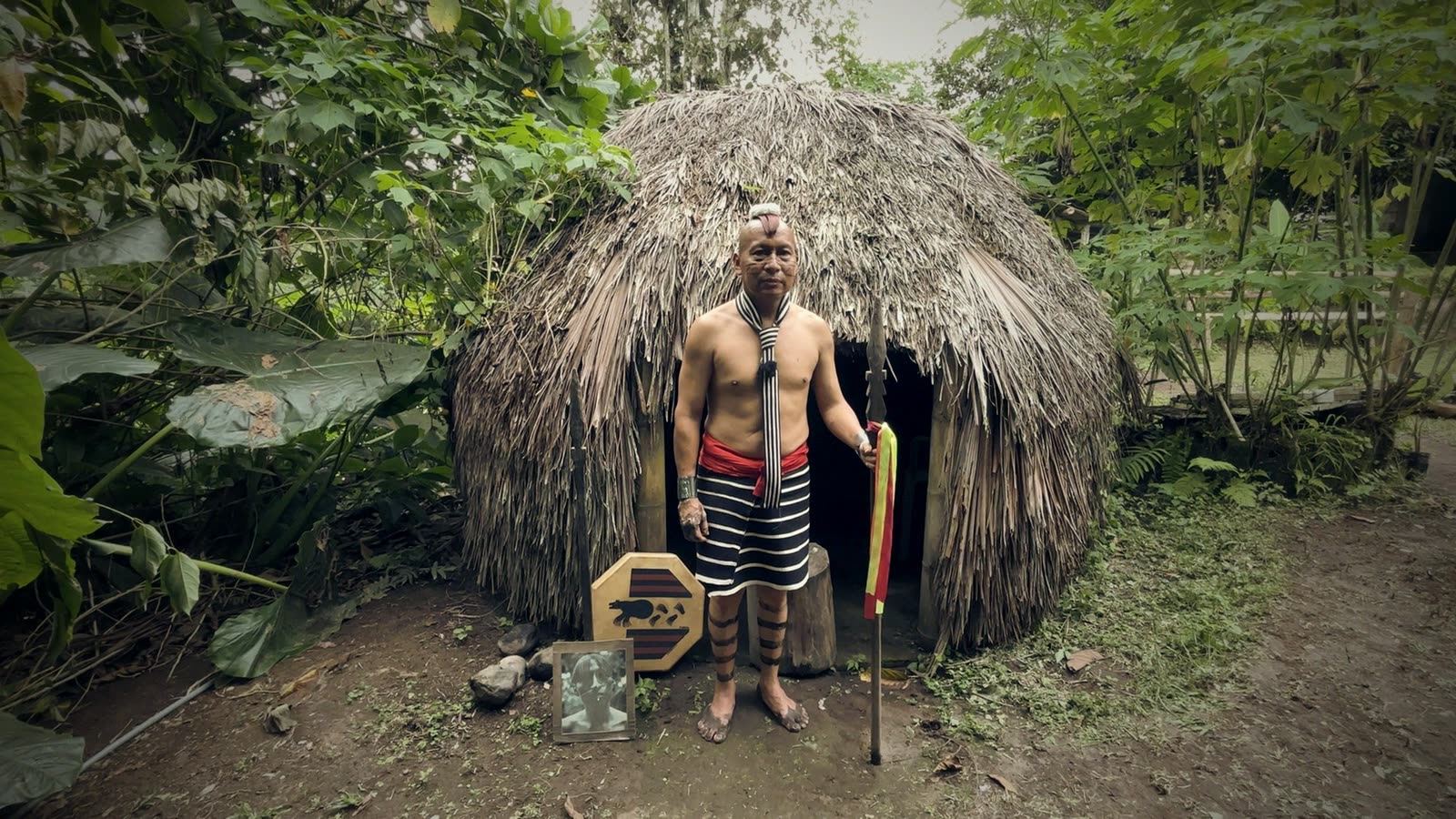 Chamán tsáchila frente a una choza de paja